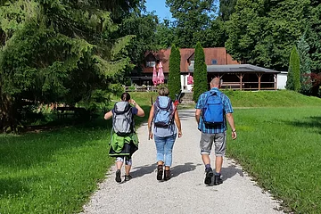 Wanderer auf den letzten Metern zur Einkehr in der Waldschänke Eisbrunn, die im Hintergrund zu sehen ist.