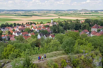 Wanderer auf dem Wallersteiner Felsen. Im Hintergrund sieht man Wallerstein.