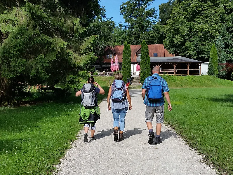 Einkehrschwung Wanderer auf den letzten Metern zur Einkehr in der Waldschänke Eisbrunn, die im Hintergrund zu sehen ist.