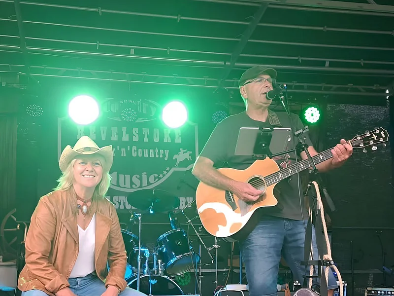 Dargestellt sind die Künstler Tom und Bine. Tom spielt Gitarre und singt, während Bine auf einer Kistentrommel spielt