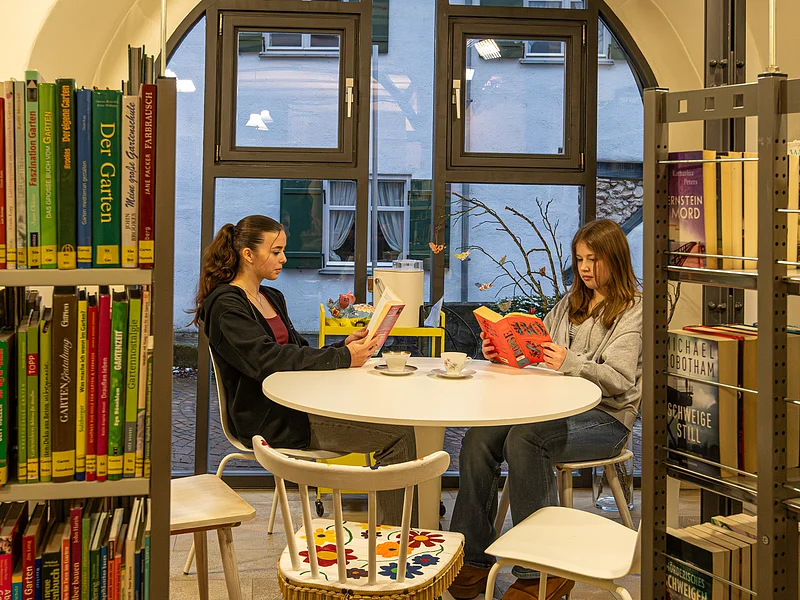 Lesen in der Bücherei Zwei Mädchen lesen im Lesebereich der Bücherei