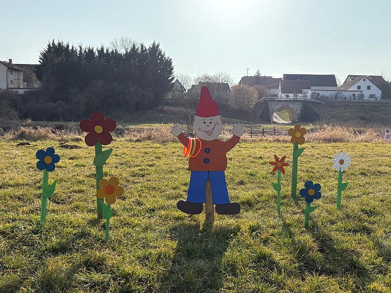 Wichtelweg Bild Zwerg Ein Wichtel aus Holz mit bunten Blumen darum