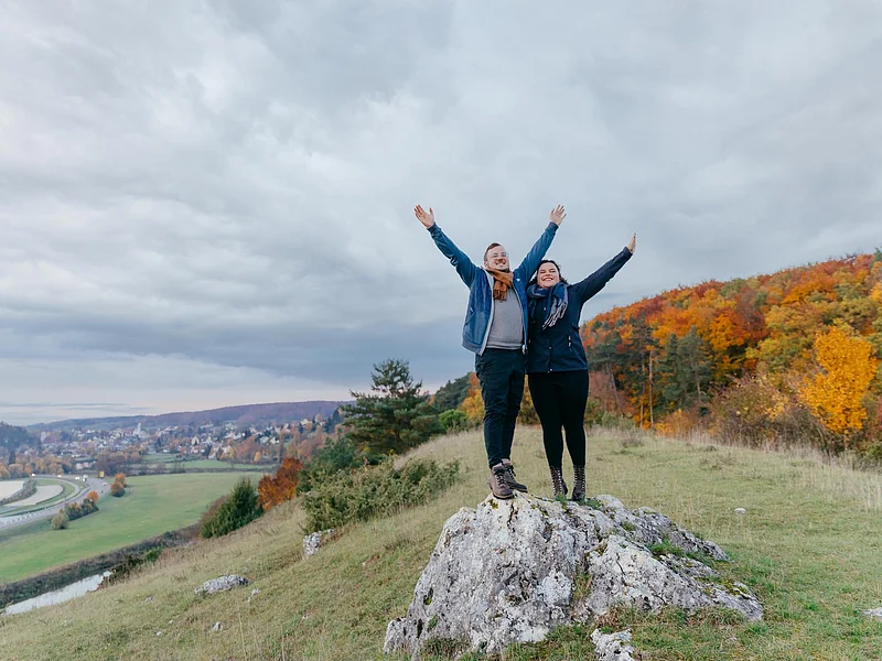 Wandern in Harburg Ein Pärchen unterwegs auf der Heide bei Harburg vor einem herbstlich buntem Wald. Links im Hintergrund sieht man die Wörnitz und die Stadt Harburg.