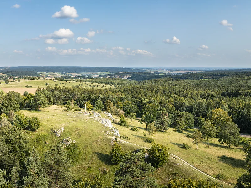 Aussicht über den Bockberg Drohnenfoto vom Bockberg bei Harburg mit grünen Hügeln und blauem Himmel. In der Mitte das Gipfelkreuz des Bockbergs